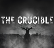 Black and white image of a girl on a stake with branches growing out of her arms. Smoke and dark lighting with The Crucible in rough looking letters