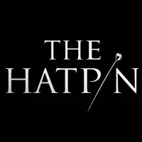 White text of "The Hatpin" on a black background. The i is replaced with an image of a hat pin.