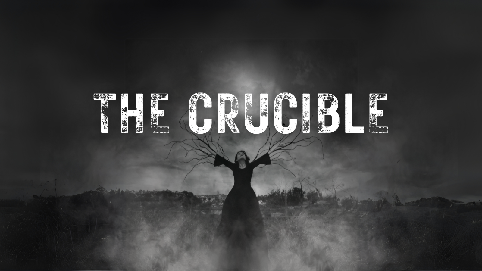 Black and white image of a girl on a stake with branches growing out of her arms. Smoke and dark lighting with The Crucible in rough looking letters